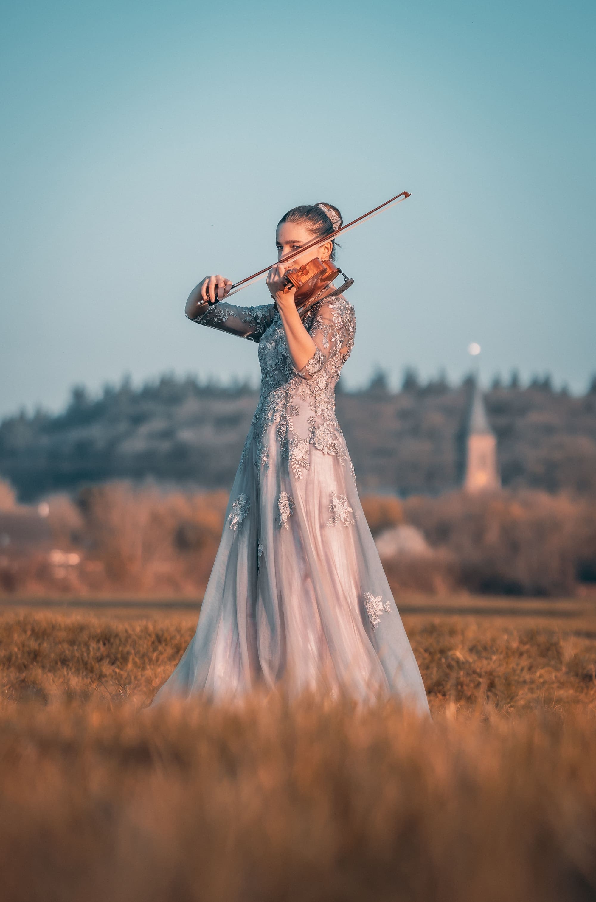 Kim Marie Borger spielt Viola im Abendlicht eines weiten Feldes